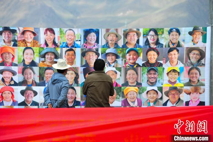 圖為當(dāng)?shù)孛癖娫谟^看展板上的笑臉?！垈?攝