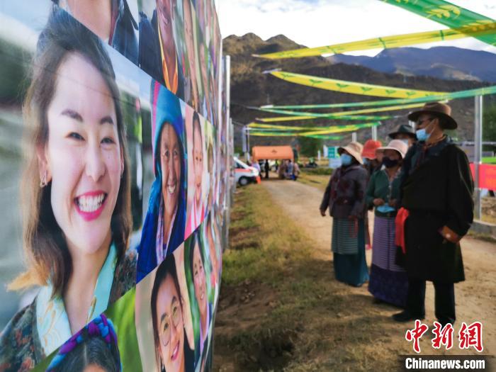 圖為當(dāng)?shù)孛癖娫谟^看展板上的笑臉?！垈?攝