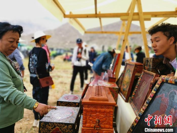 圖為拉薩市民在特色農(nóng)畜產(chǎn)品展示展銷會上選購商品?！垈?攝
