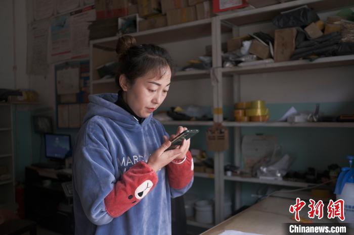 正在快遞站點內(nèi)忙碌的楊莉春?！『闻罾?攝