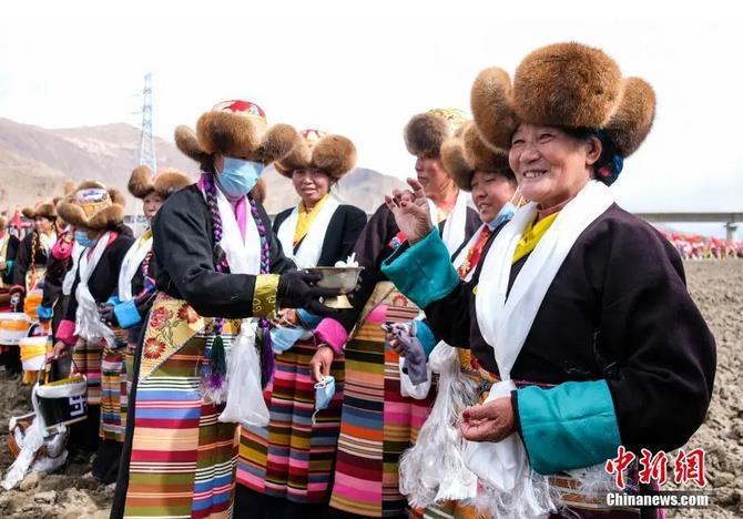 資料圖：西藏自治區(qū)拉薩市曲水縣才納鄉(xiāng)協(xié)榮村參加春耕儀式的村民互敬青稞酒。按照傳統(tǒng)，當(dāng)?shù)卮迕裆碇?jié)日盛裝，舉行隆重的儀式，祈福一年的豐收。<a target='_blank' ><p  align=