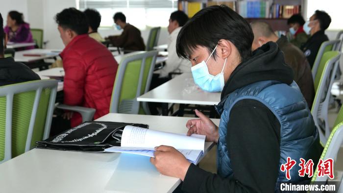 圖為正在閱讀“杰松達孜”藏歷法教材的學(xué)員。　謝牧 攝