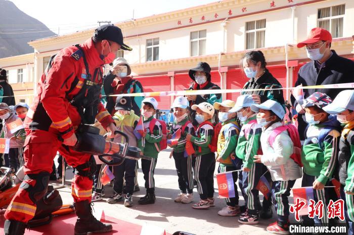 圖為消防指戰(zhàn)員為學(xué)生講解、演示先進救援裝備?！≮w琳 攝