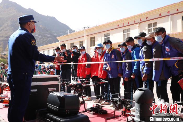 圖為消防指戰(zhàn)員為學(xué)生講解、演示先進救援裝備?！≮w琳 攝