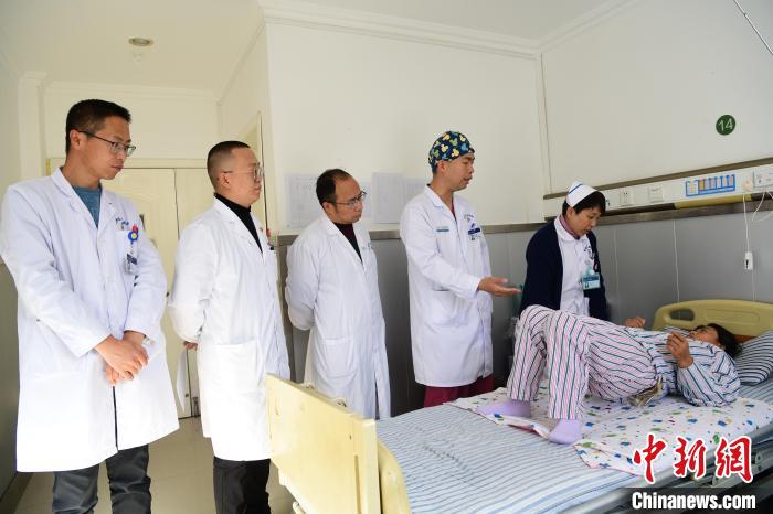 圖為何蔚副主任醫(yī)師(站右二)及團隊術(shù)后指導患者進行腰背肌鍛煉。　貢嘎來松 攝