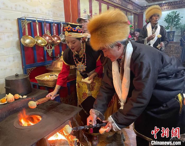 圖為人們在火上烤節(jié)日美食“結(jié)達(dá)”。　冉文娟 攝