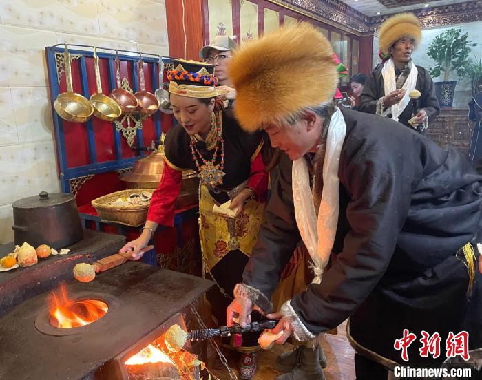 圖為人們?cè)诨鹕峡竟?jié)日美食“結(jié)達(dá)”?！∪轿木?攝