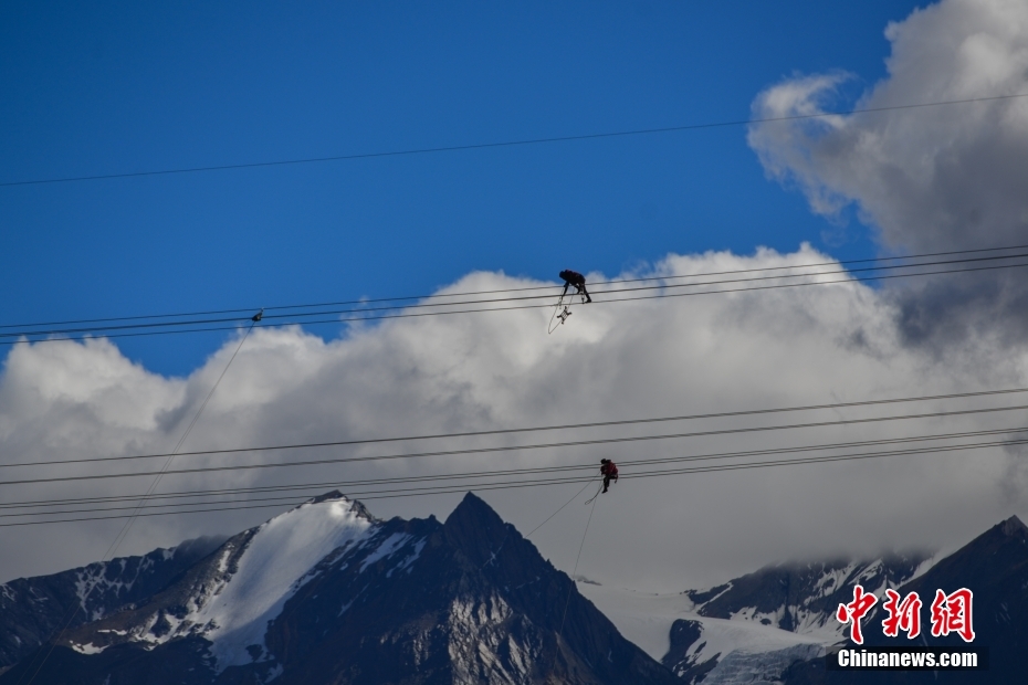資料圖為2020年6月23日，西藏阿里聯(lián)網(wǎng)工程施工人員在日喀則希夏邦馬雪山附近進(jìn)行走線作業(yè)，安裝絕緣設(shè)備。 <a target='_blank' href='/'><p  align=