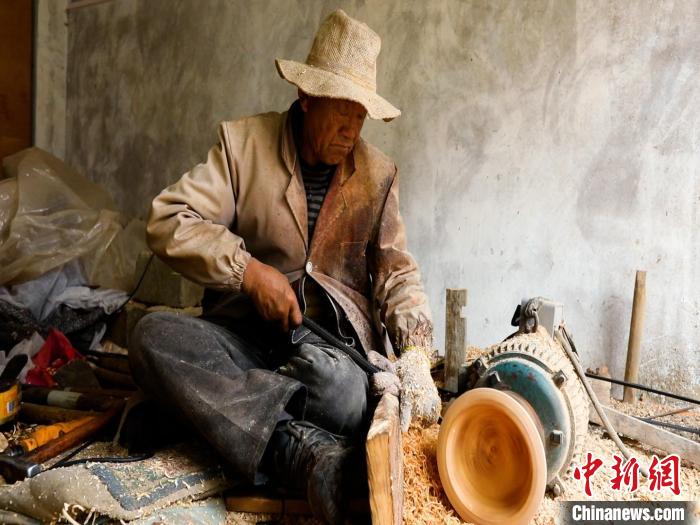 圖為手工藝人正在制作木碗。　 鄧海平 攝