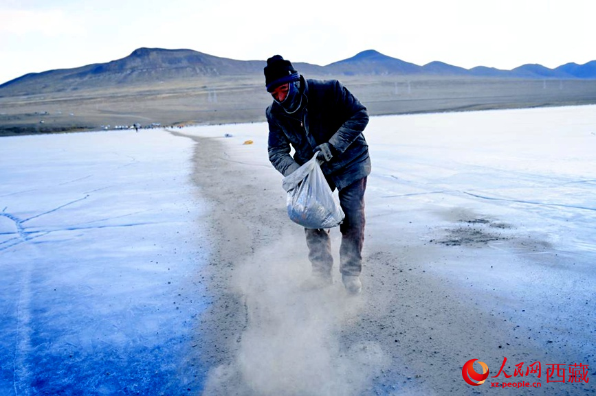牧民在冰面上撒灰鋪成通道。人民網(wǎng) 李海霞攝