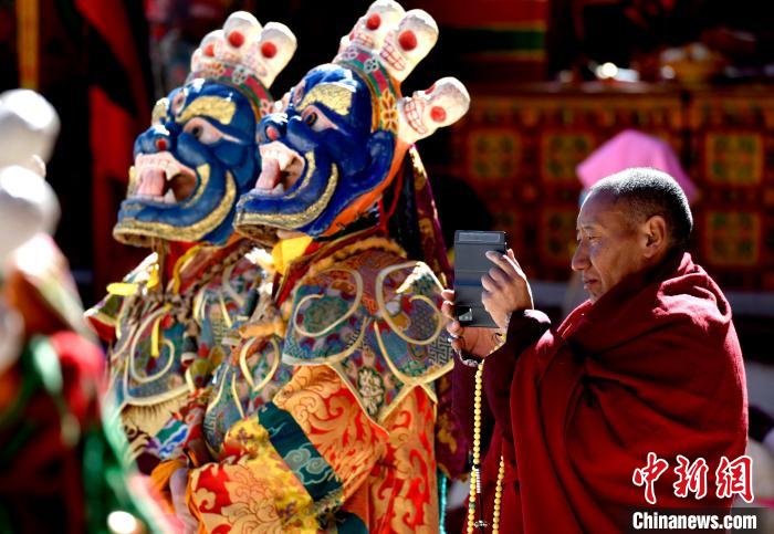 2月19日，正在拍攝跳神活動的僧人?！±盍?攝
