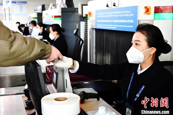 圖為機場工作人員為旅客辦理行李托運?！≈芎?攝