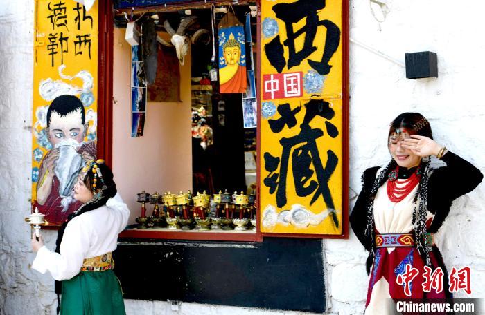 4月17日，游客身著藏式元素服裝在拉薩八廓街拍照留念。　李林 攝