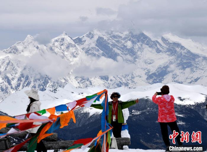 圖為5月14日，西藏林芝色季拉山觀景臺，游客與南迦巴瓦峰合影。　李林 攝