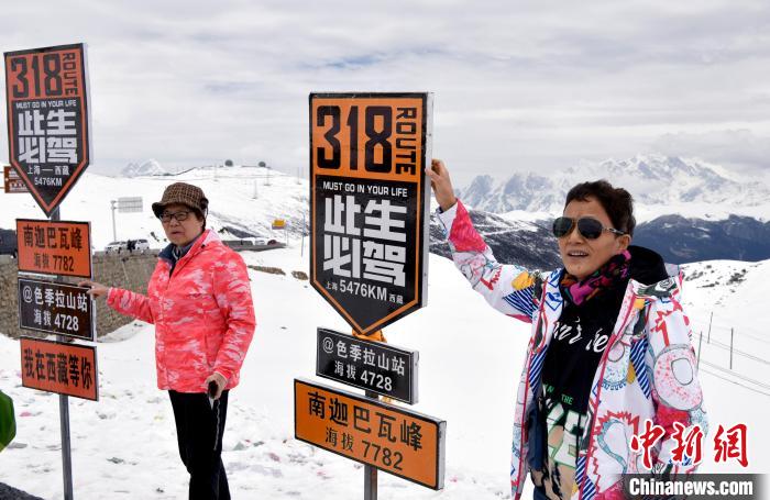 圖為5月14日，西藏林芝色季拉山觀景臺，游客與南迦巴瓦峰合影?！±盍?攝