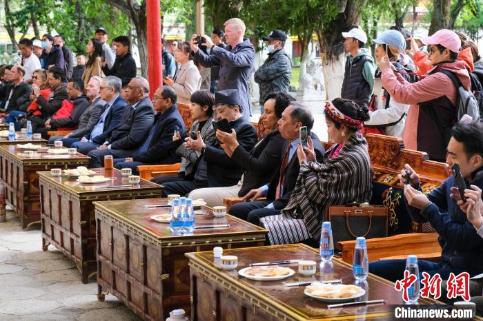 5月19日，中外嘉賓在羅布林卡和游客一起觀看藏戲?！〗w波 攝