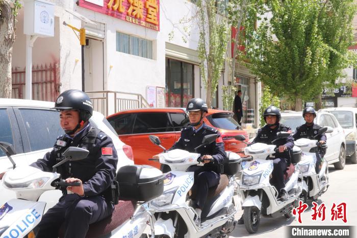 民警騎著電瓶車在轄區(qū)巡邏走訪?！↑S創(chuàng)偉 攝