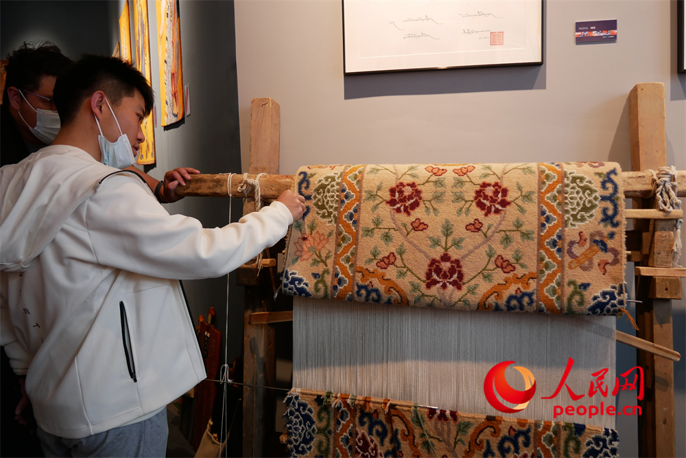 觀眾正在觀賞展出的藏毯。人民網(wǎng) 韋衍行攝