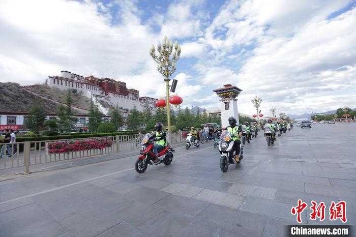 圖為比賽選手途經(jīng)布達拉宮?！∮文恋厍蚬﹫D