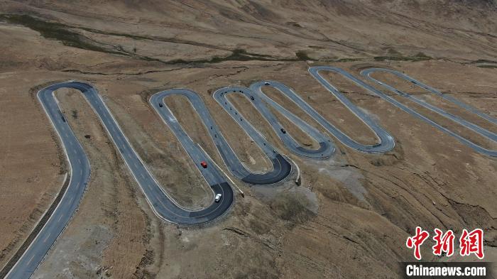 圖為騎手前往珠峰大本營途經(jīng)108道拐?！∮文恋厍蚬﹫D