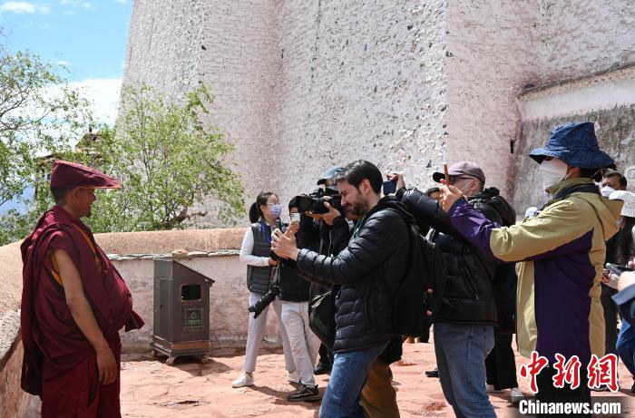 圖為中外媒體拍攝朝拜布達(dá)拉宮的僧人?！≮w朗 攝