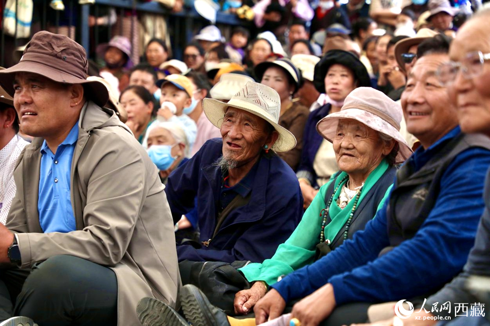 當(dāng)?shù)厝罕姾陀慰陀^看藏戲演出。