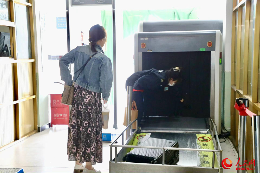 車站工作人員幫旅客提取行李。人民網(wǎng)記者 次仁羅布攝