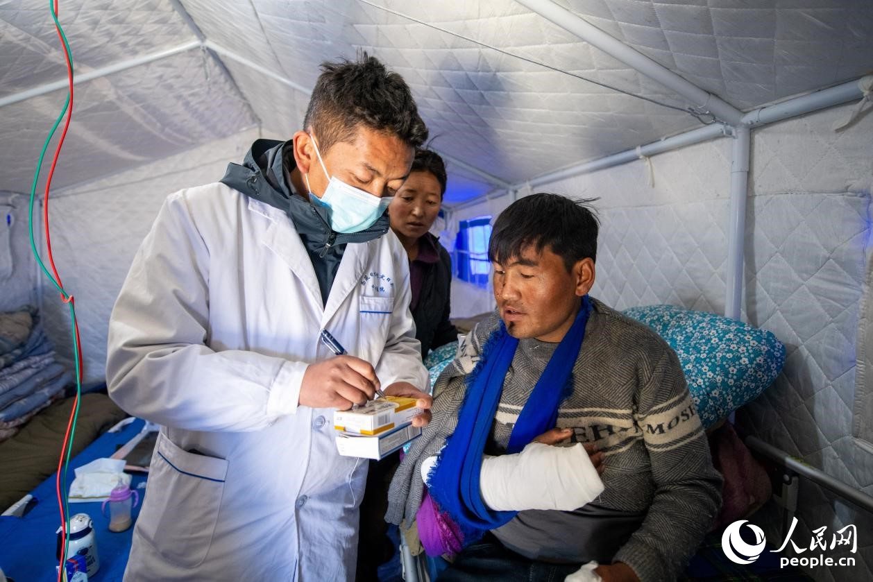 　醫(yī)生正在囑咐洛桑堅參如何用藥。人民網(wǎng)記者 翁奇羽攝