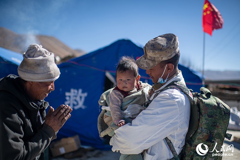 1月9日，在定日縣長所鄉(xiāng)古榮村安置點，受災(zāi)群眾感謝西藏軍區(qū)陸軍某部隊衛(wèi)生員的醫(yī)療救治。人民網(wǎng)記者 翁奇羽攝