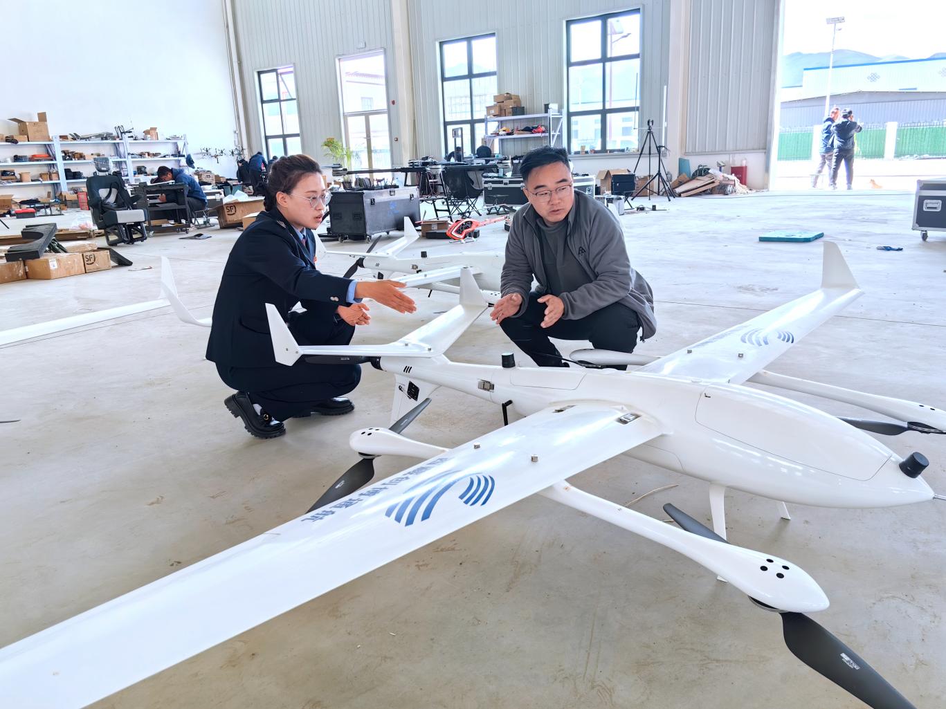 創(chuàng)博通航工作人員向稅務(wù)干部介紹無人機情況。曲麗攝
