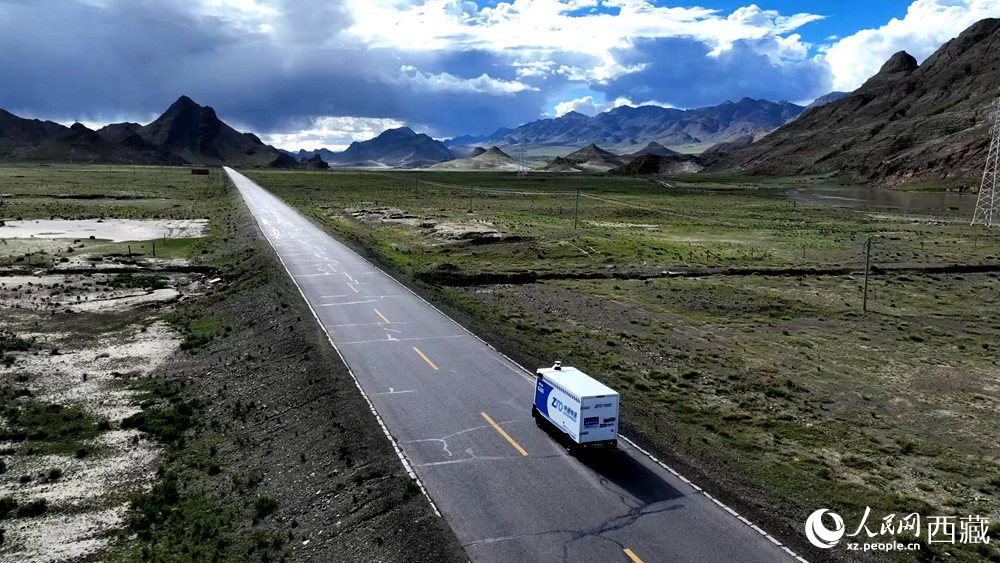 一輛無人快遞車正沿著定日縣通往扎果鄉(xiāng)的道路平穩(wěn)行駛。人民日?qǐng)?bào)記者 鮮敢攝