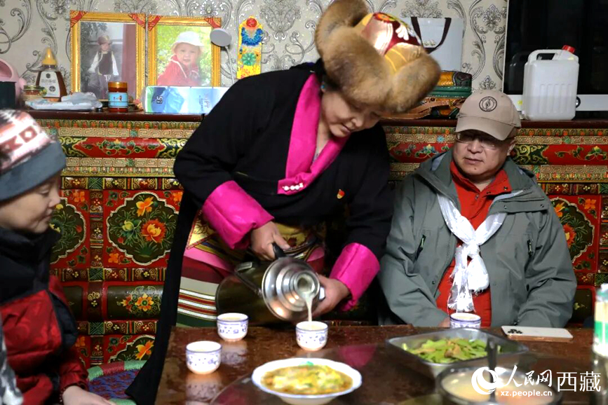 扎西曲登社區(qū)的居民在家中熱情招待遠(yuǎn)道而來(lái)的游客。居民身著盛裝，為游客倒上熱騰騰的酥油茶，桌上擺放著切瑪與特色美食，賓主共話民族團(tuán)結(jié)情誼。人民網(wǎng)記者 吳雨仁攝