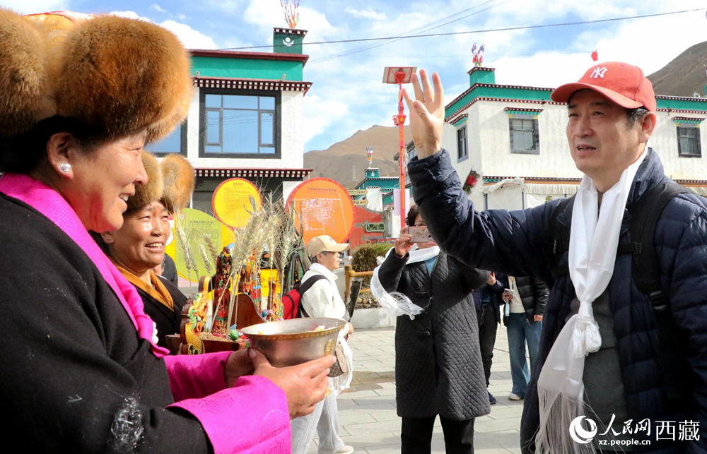 藏族同胞向游客敬獻(xiàn)青稞酒。人民網(wǎng)記者 吳雨仁攝