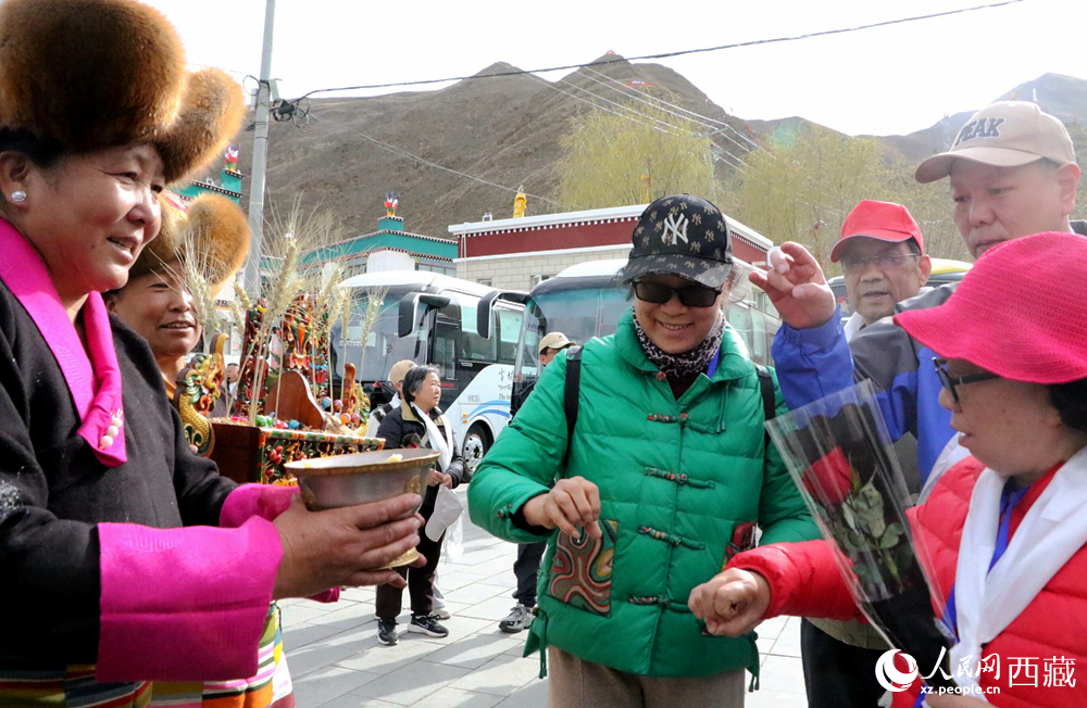 藏族同胞向游客敬獻(xiàn)青稞酒。人民網(wǎng)記者 吳雨仁攝