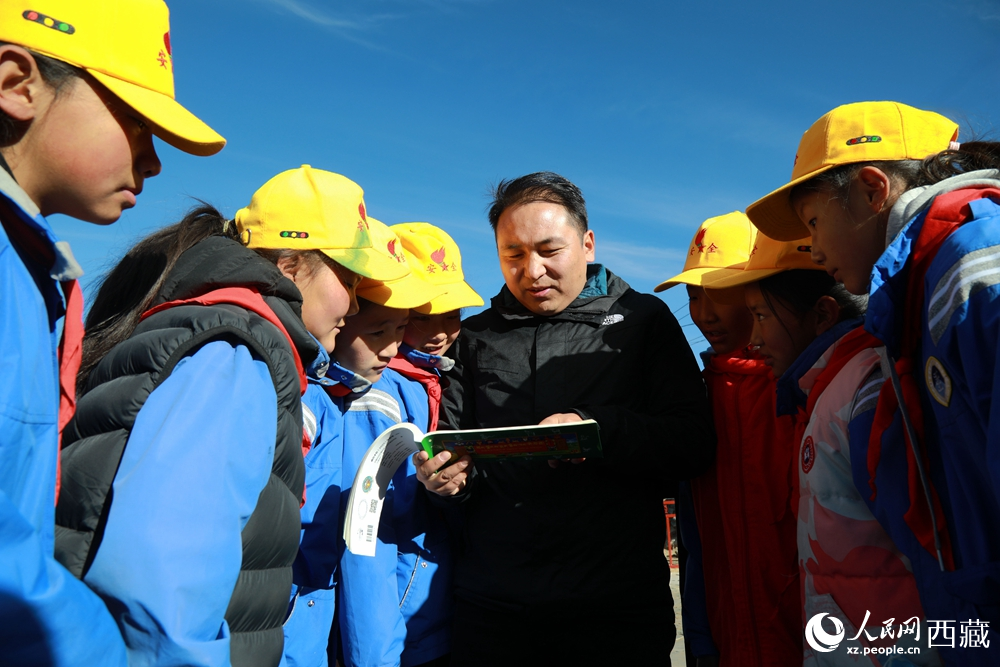 西藏自治區(qū)藏醫(yī)院專家為拉東村小學(xué)生講解天文歷算原理，孩子們圍站聆聽(tīng)，感受傳統(tǒng)智慧與現(xiàn)代科普的融合。人民網(wǎng)記者 吳雨仁攝