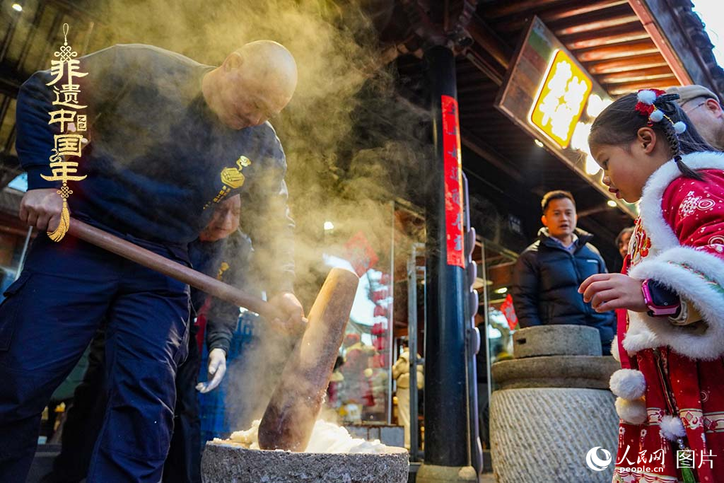 2025年1月29日，浙江省寧波市江北區(qū)慈城古縣城，市民和游客觀看搗年糕。人民網(wǎng) 章勇濤攝
