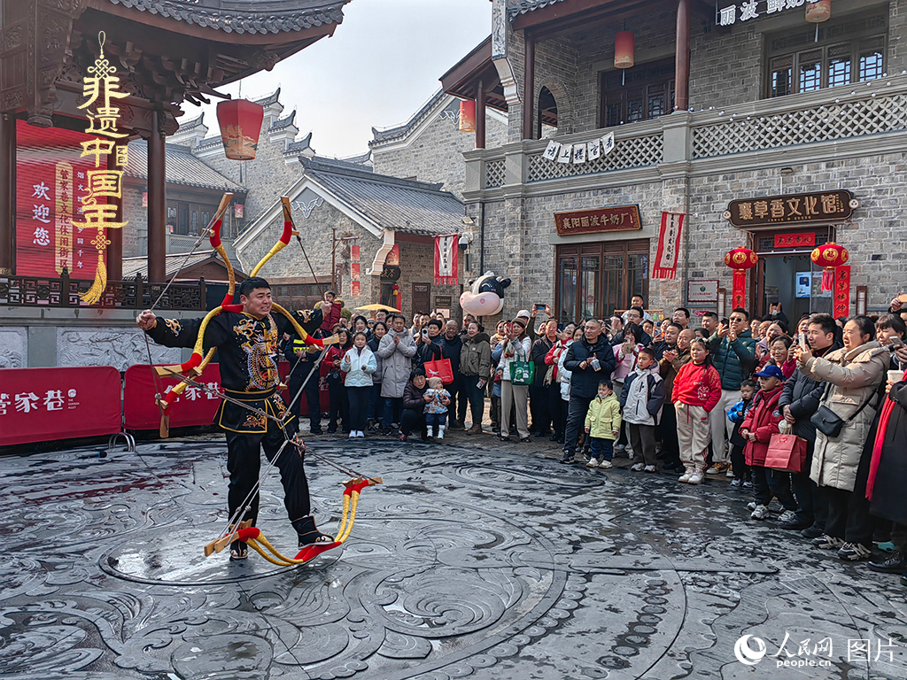 2025年1月29日，湖北襄陽(yáng)市管家巷，老北京天橋大刀張舉大刀拉硬弓第五代傳承人現(xiàn)場(chǎng)表演，一次拉開(kāi)6張弓，引來(lái)游客喝彩。人民網(wǎng)記者 郭婷婷攝