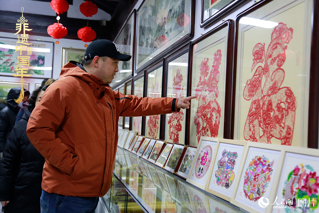 2025年1月23日，游客在天津楊柳青古鎮(zhèn)欣賞傳統(tǒng)剪紙作品，感受指尖上的古老藝術(shù)。人民網(wǎng)記者 崔新耀攝