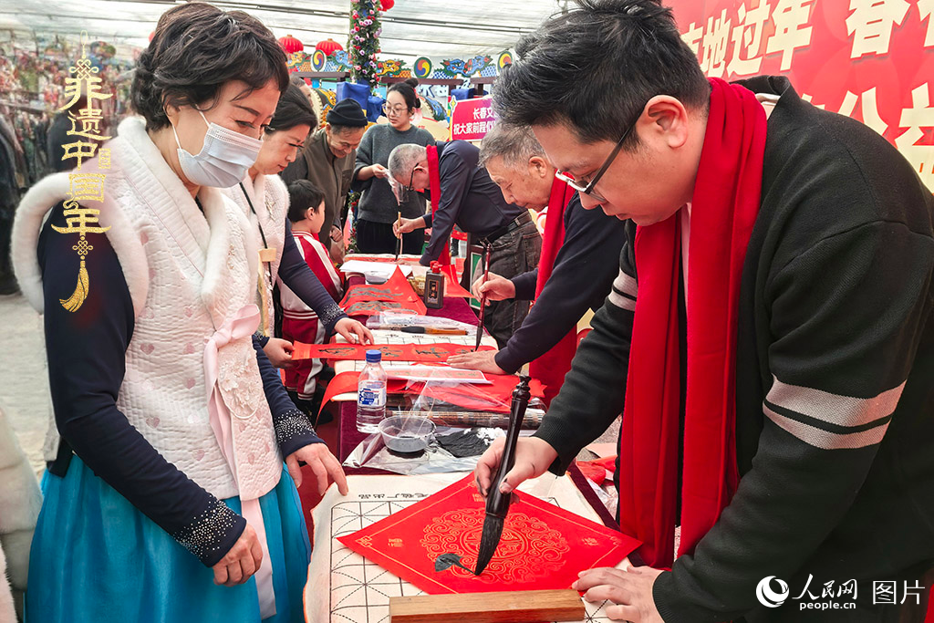 新春佳節(jié)之際，長(zhǎng)春農(nóng)博園冬季展會(huì)火熱進(jìn)行，展廳內(nèi)，書(shū)法家現(xiàn)場(chǎng)書(shū)寫(xiě)“?！弊郑忻裼慰图娂娚锨坝航印案！?。人民網(wǎng)記者 王海躍攝