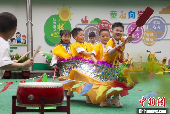 圖為龍舟賽游戲上，小伙伴們打鼓加油。　董觀生 攝